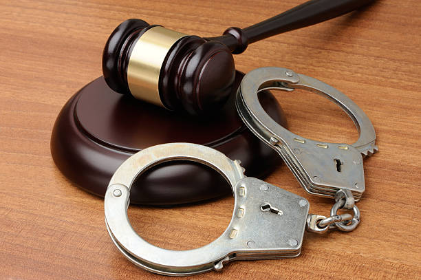 handcuffs-with-gavel-on-a-wood-background-picture-id504104838